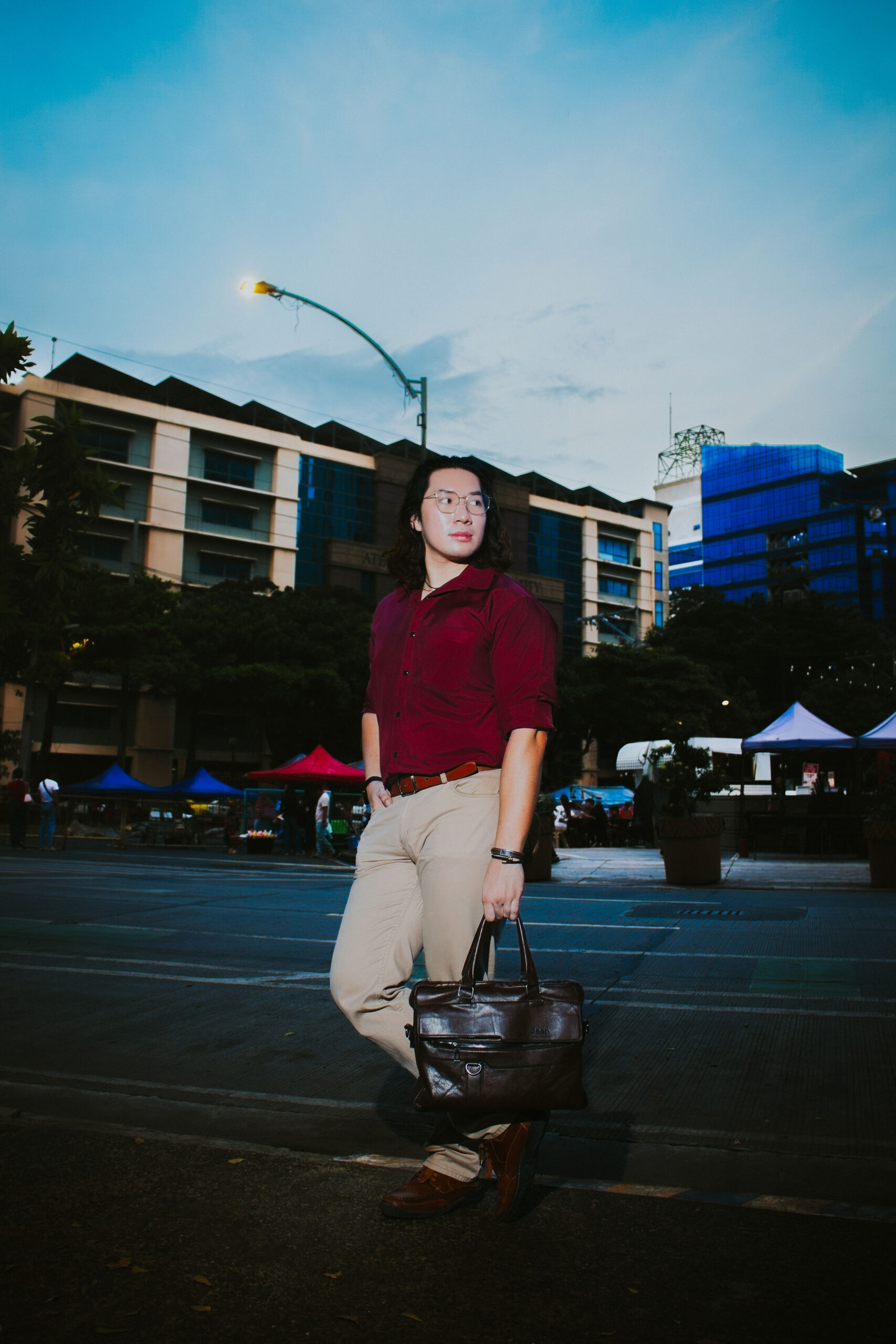 Liam standing in a plaza at blue hour under a street lamp